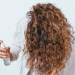 Women spraying water on her hair